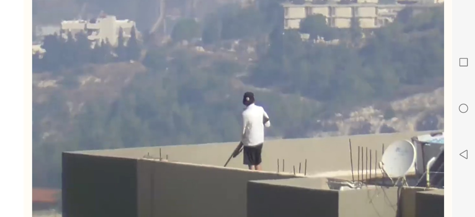 صياد يحمل بندقية على سطح مبنى في بيروت.